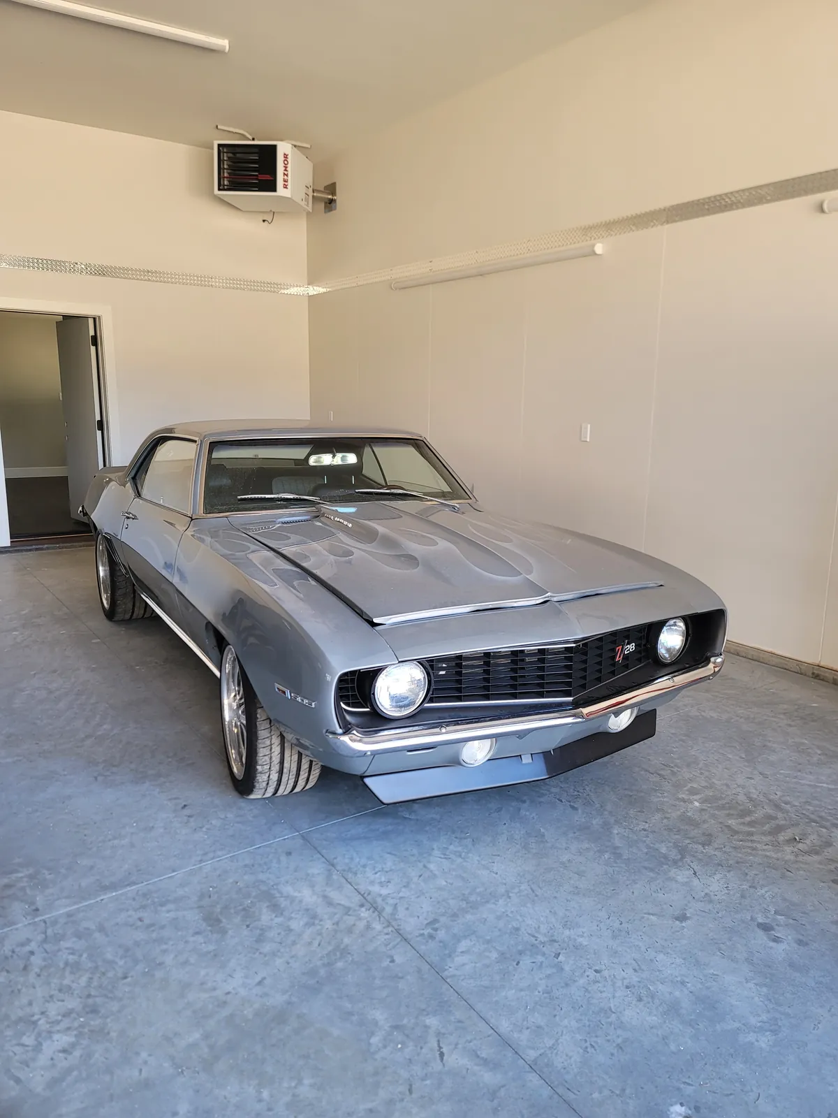 Silver 1969 Chevrolet Camaro staged indoors for enclosed transport pickup.