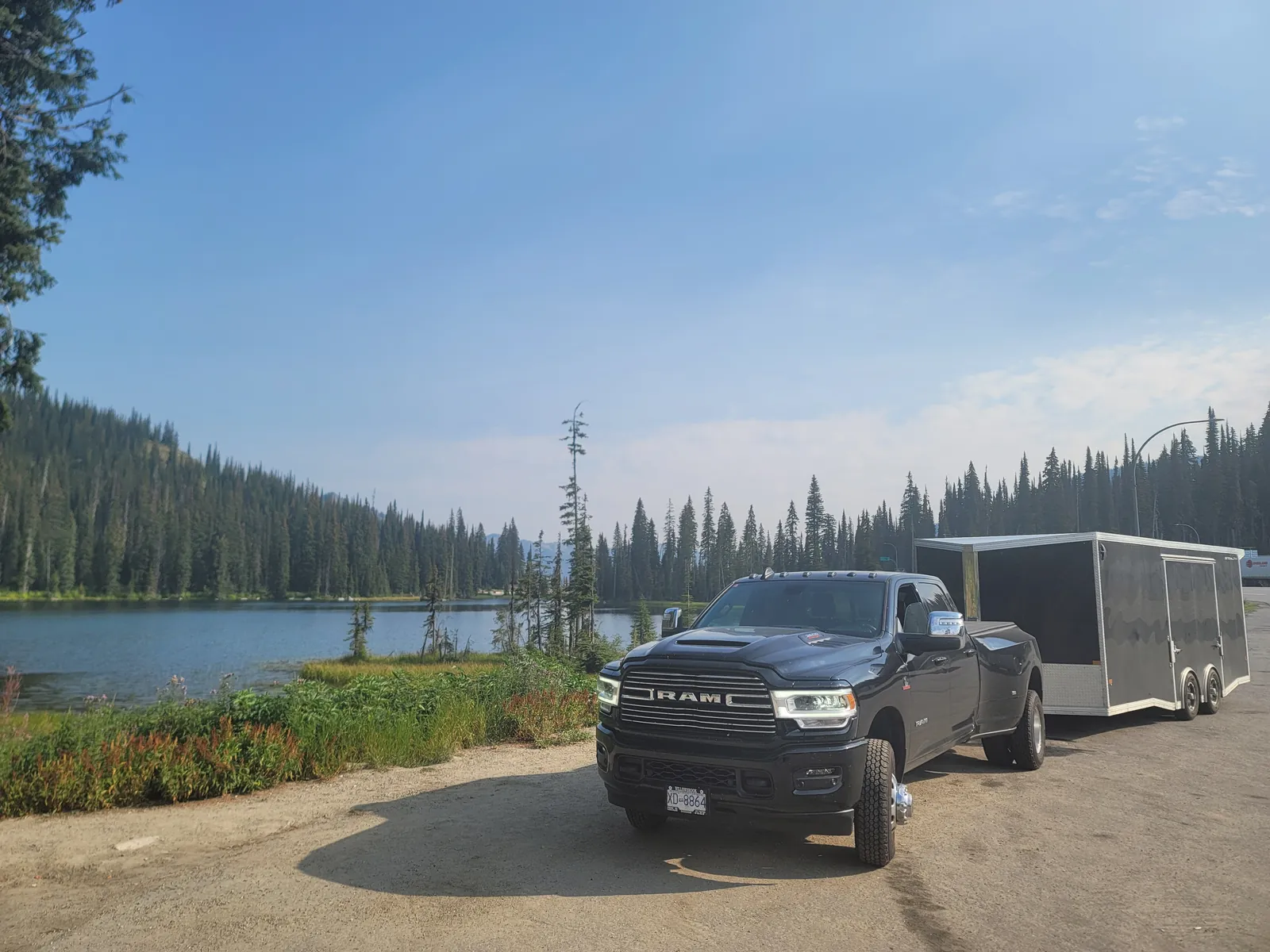 Coast2Coast truck and enclosed trailer parked by a mountain lake on a long-distance route.